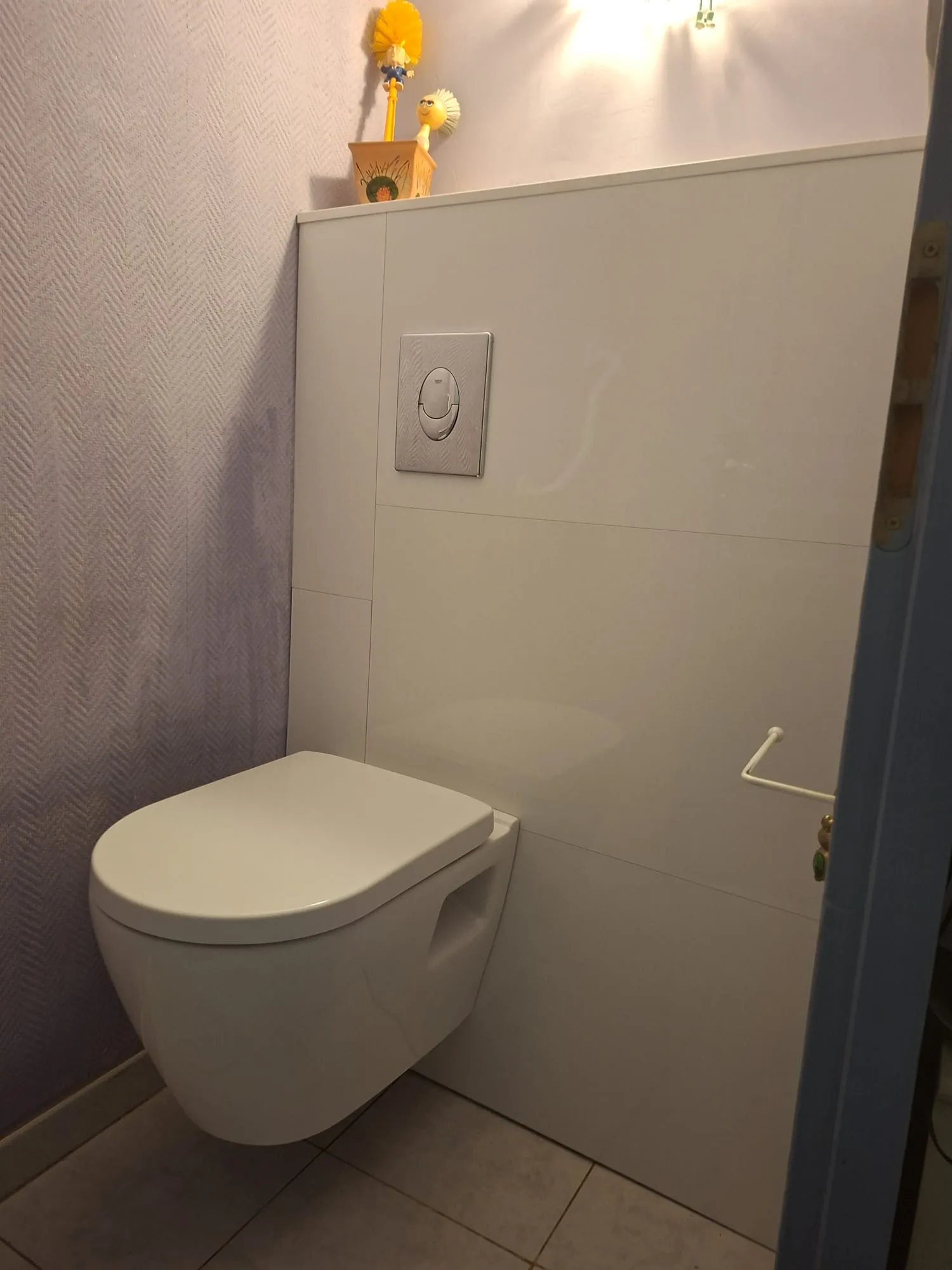 WC suspendu rénové avec habillage laqué blanc toute hauteur et plaque de commande chromée, par Bony Plomberie