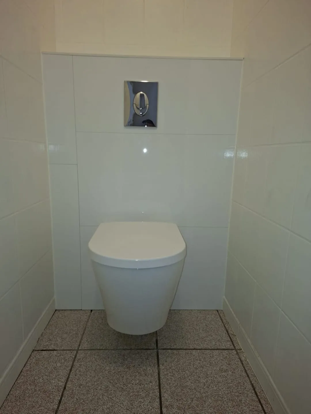 WC suspendu neuf avec plaque de commande chromée et habillage carrelé blanc par Bony Plomberie